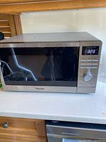 Front view of Panasonic stainless countertop microwave with display lit