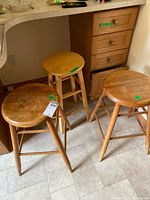 Three wooden bar stools under counter