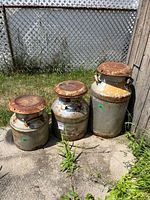 All three milk cans outdoors showing size comparison