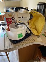 Full view of mixer, bowls, manual, cover and rack on countertop