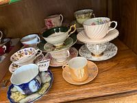 Cabinet view showing multiple teacup and saucer sets