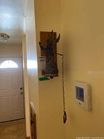 Full view of wall-mounted bell on plaque in hallway