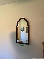 Full view of wall-mounted arch mirror on wall