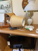 Table lamp and both wall sconces atop shelving unit