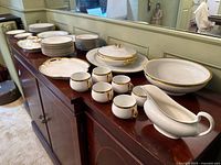 Overview of entire dinnerware lot displayed on sideboard