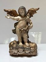 Front view of carved wood cherub on cloud base showing gilded wings and polychrome finish