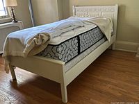 Assembled painted single bed frame with mattress to illustrate overall design