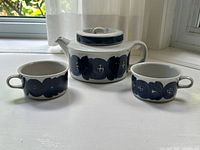 Teapot with lid and two matching cups displayed