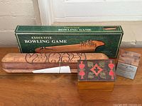 All four game and puzzle items grouped: boxed Executive Bowling Game, carved Oware board, solitaire box, Ancient Key puzzle with card