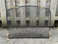 Front view of entire fireplace screen showing mesh, brass feet and arched top