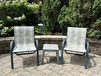 Two patio chairs and side table on stone patio