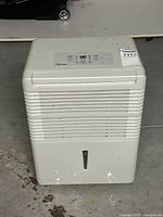 Front view of dehumidifier showing vents and water level window