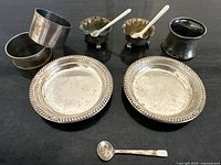 Group shot of all sterling dishes, napkin rings, salt cellars, spoons
