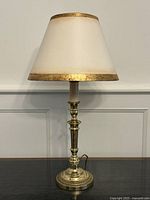 Full view of brass candlestick lamp with shade