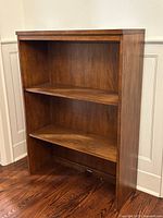 Front angled view of wood bookcase showing shelves and finish