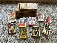 Wide view of wooden box filled with hockey cards and multiple stacks spread out showing variety