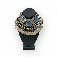 Front view of Afghan silver tone necklace with faux lapis stones and multiple coin pendants arranged on black display bust.
