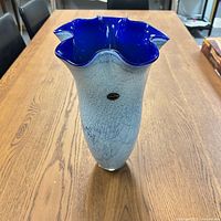 Blue and white art glass vase showing ruffled cobalt blue rim and crackled light blue body with Fenton label