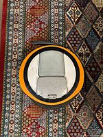 Top view of electric unicycle showcasing orange and gray plastic shell with foot pedal and handle