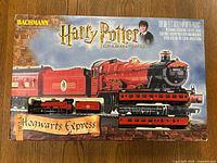 Front of the box showing the Bachmann brand, Harry Potter and the Chamber of Secrets title, and image of the red Hogwarts Express train including locomotive, tender, and passenger cars.