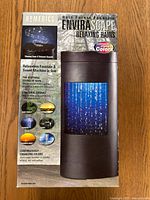 Front view of the boxed Homedics EnviraScape Rain Forest Fountain showing product details, features, and image of the waterfall with changing colors.