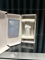 Figurine in original box showing child in bathrobe with towel on head and dog at feet, with foam padding and booklet.