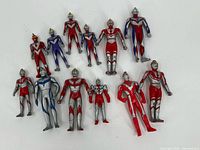 Top view of 13 Ultraman plastic action figures, showing detailed colors and helmets, grouped on a white surface.