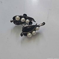 Pair of sterling silver screwback earrings with a leaf motif and four cultured pearls each.