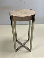 Full view of the accent table showing round wood top and chrome legs with cross base.