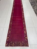 Full length view of the Persian Kashan wool runner rug showing the deep red/purple central field and intricate border designs.
