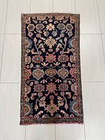 Full view of Persian Hamadan rug showing all over design and border inlay on tiled floor.