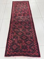 Full length view of the rectangular Mashhad Persian rug showing geometric red patterns on a brown background on tile floor.