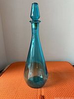 Full view of teal glass genie bottle with stopper