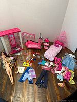 Overview of dolls, furniture pieces, clothing and accessories on table