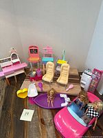 Overall lot view showing car, boat, seats, playset pieces, dolls