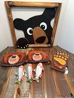 Overall lot showing bear wall art, hats, paw mitt, wooden fish