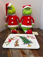 Front view showing both Grinch plush dolls and melamine tray