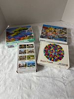 Four boxed puzzles laid out on surface