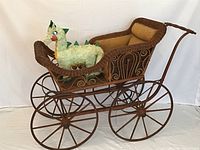 Full view of rattan pram with cushion and wheels
