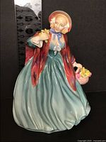 Front view of Royal Doulton Lady Charmian figurine next to ruler for scale