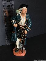 Front view of Long John Silver figurine against ruler showing ~9 in height