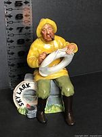 Front view of Royal Doulton The Boatman figurine holding lifebuoy, height scale visible