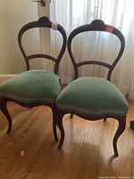 Both balloon back chairs front view on hardwood floor