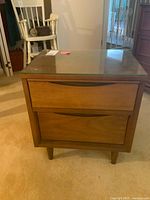 Front view of Gibbard bedside table with glass top and closed drawers