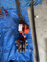 Overall view of block and tackle hoist, chain, and separate bar present