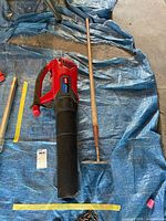 Toro Power Jet F700 blower beside wood handle hoe on tarp