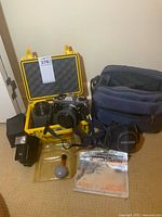 Group shot of camera, lenses, flash, cases, cleaning kit