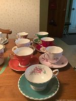 All seven teacup and saucer sets displayed on table