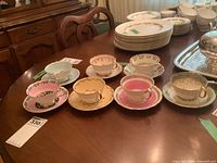 Six assorted bone china teacup and saucer sets displayed on dining table