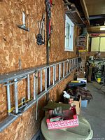 Full length of aluminum extension ladder mounted on wall